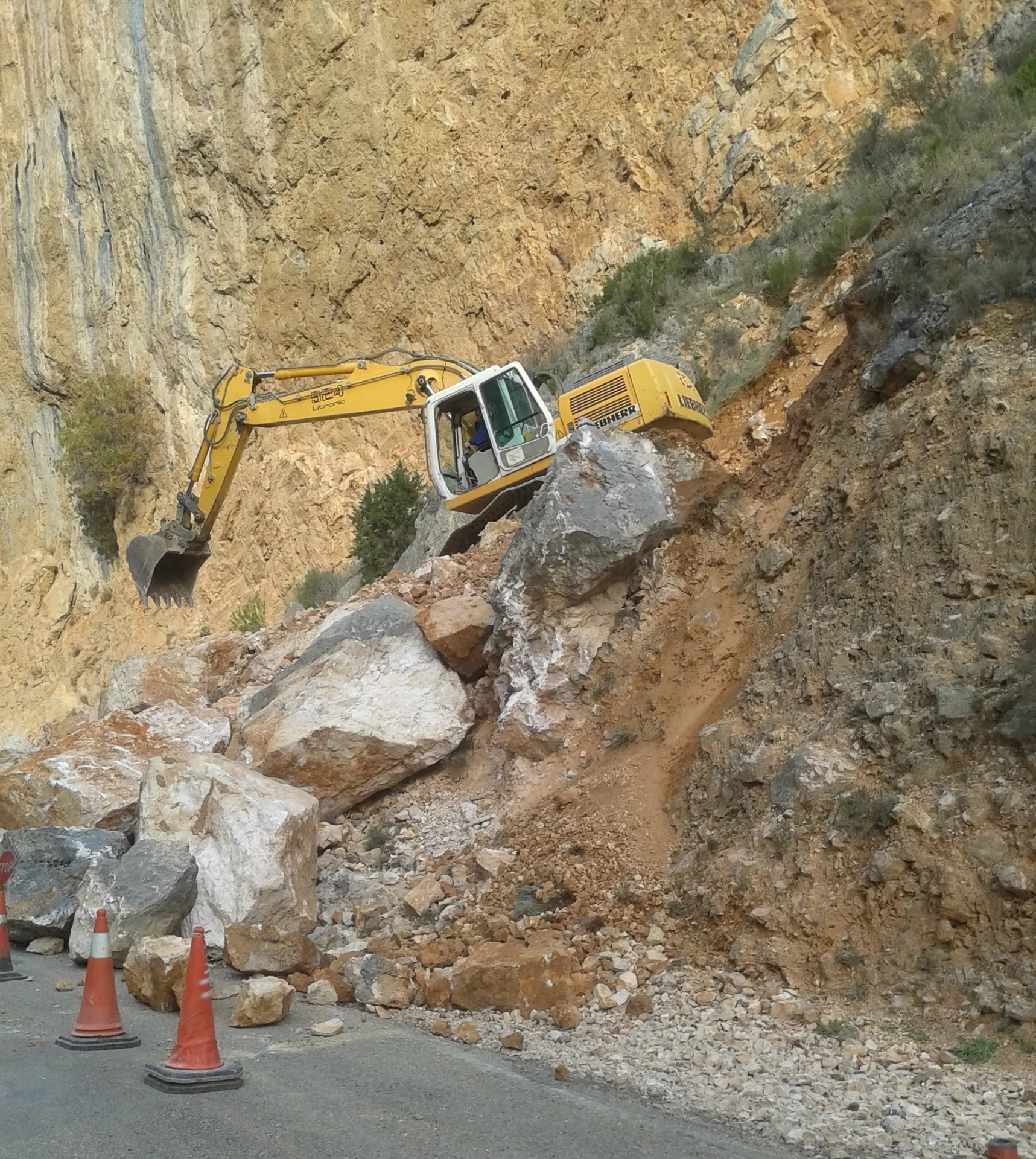 Excavadora retirando un desprendimiento en una carretera
