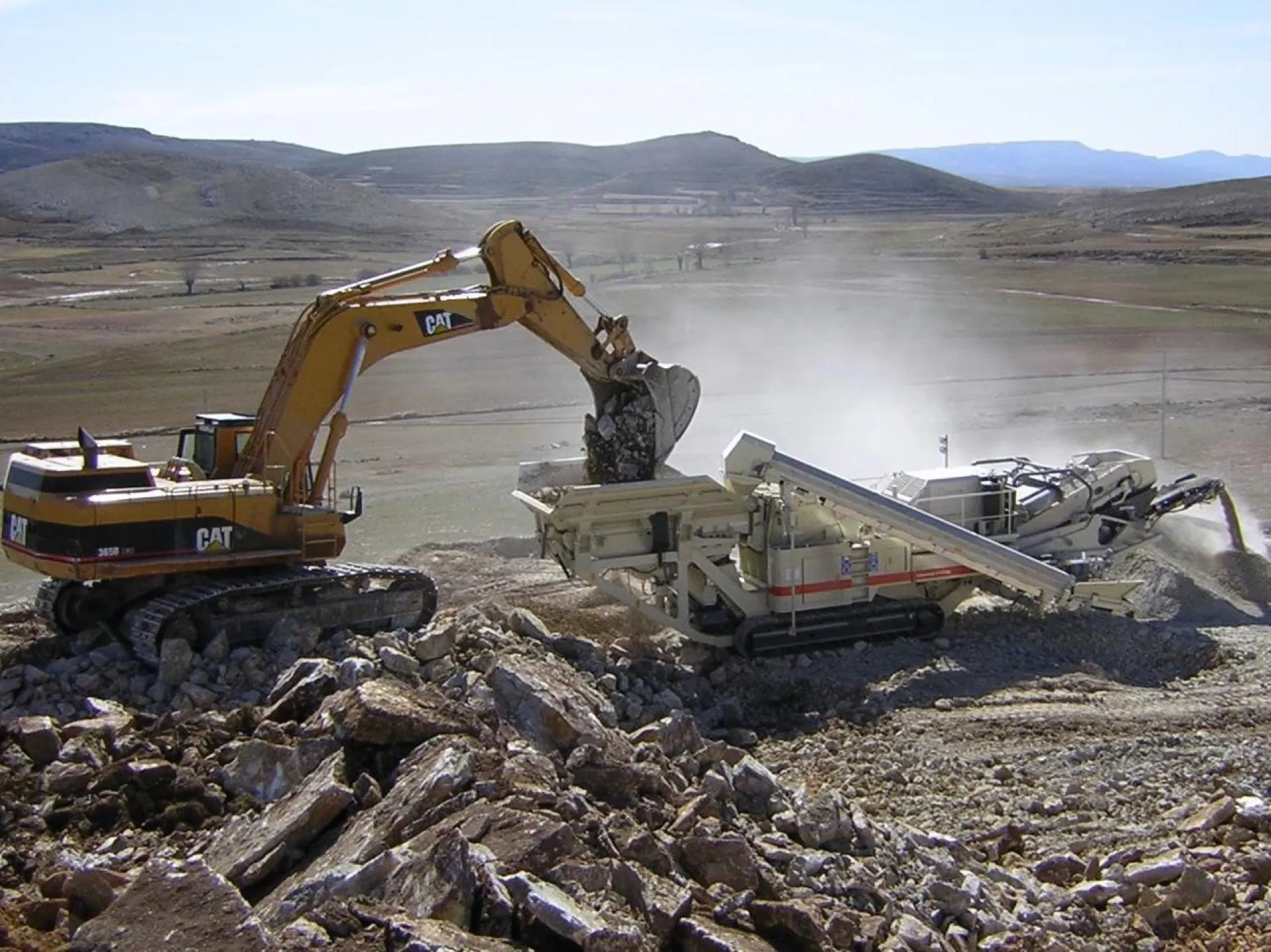 Excavadora alimentando la trituradora de áridos